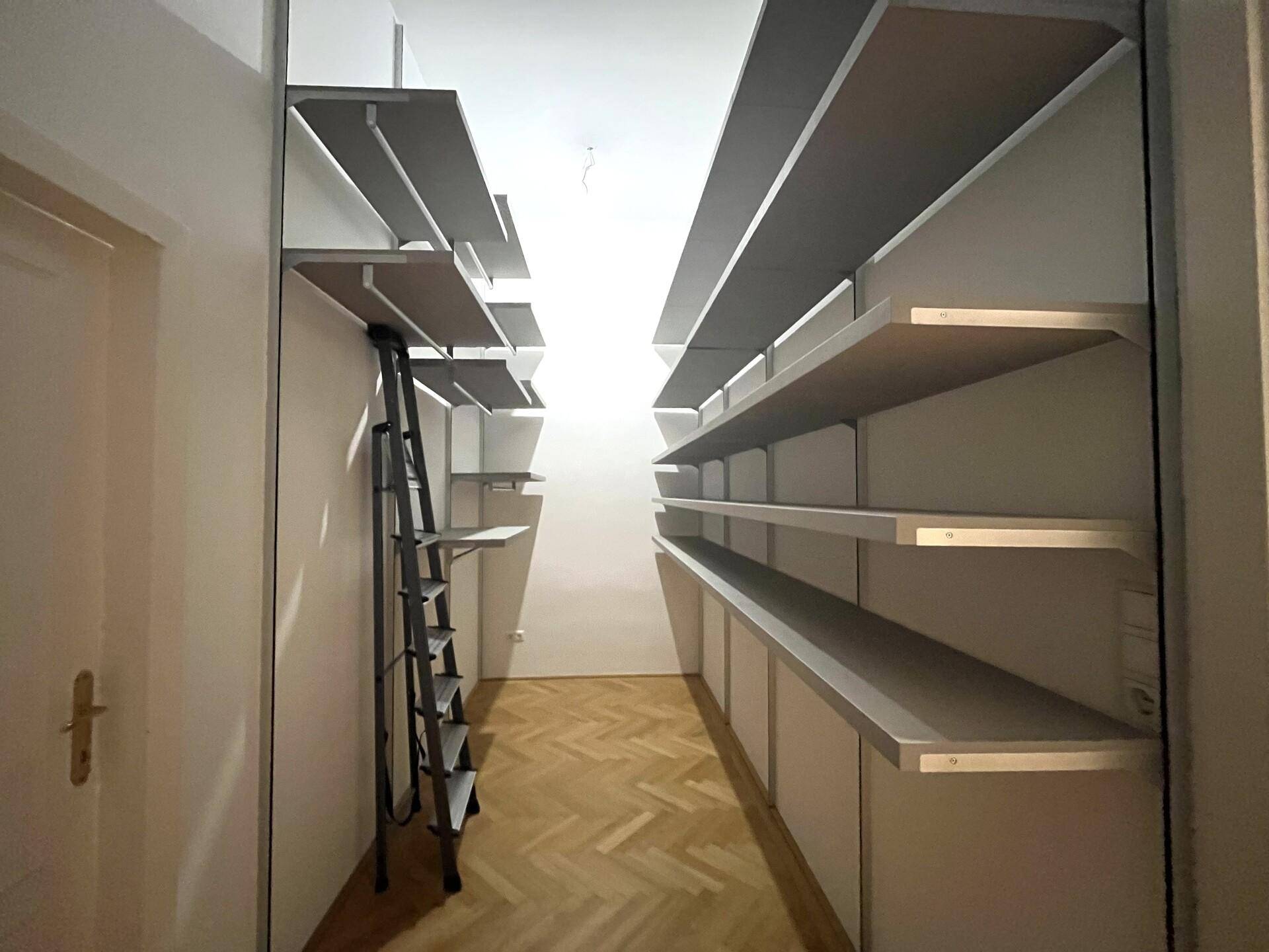 Geräumiger begehbarer Kleiderschrank mit vielen Regalen und Stauraum.