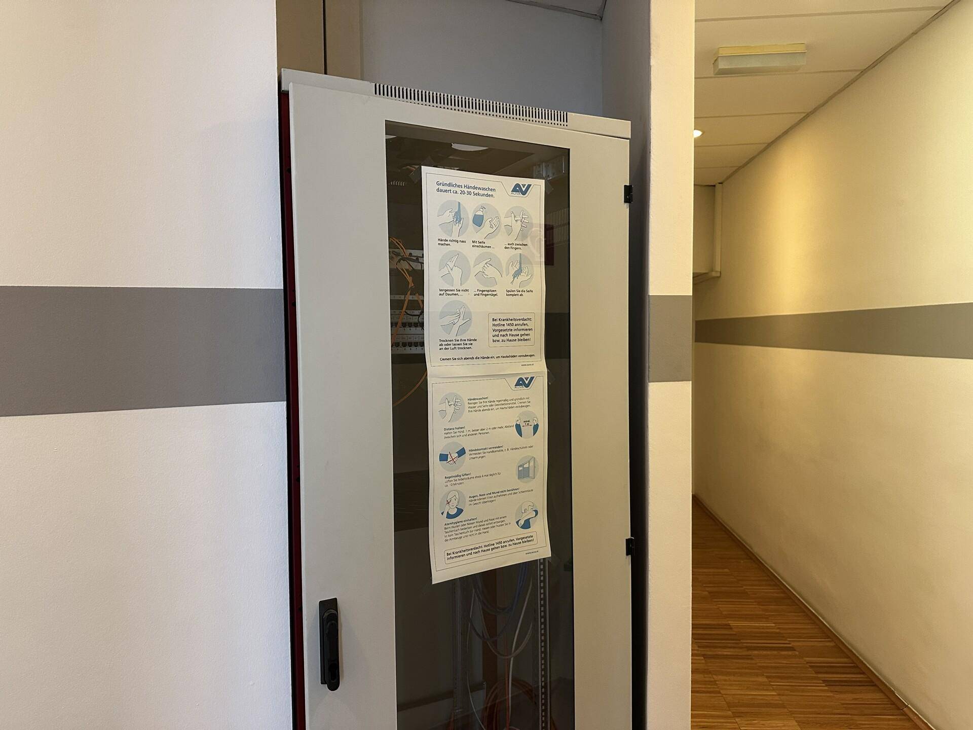 Serverschrank in einem Flur, der die technische Infrastruktur des Gebäudes beherbergt.