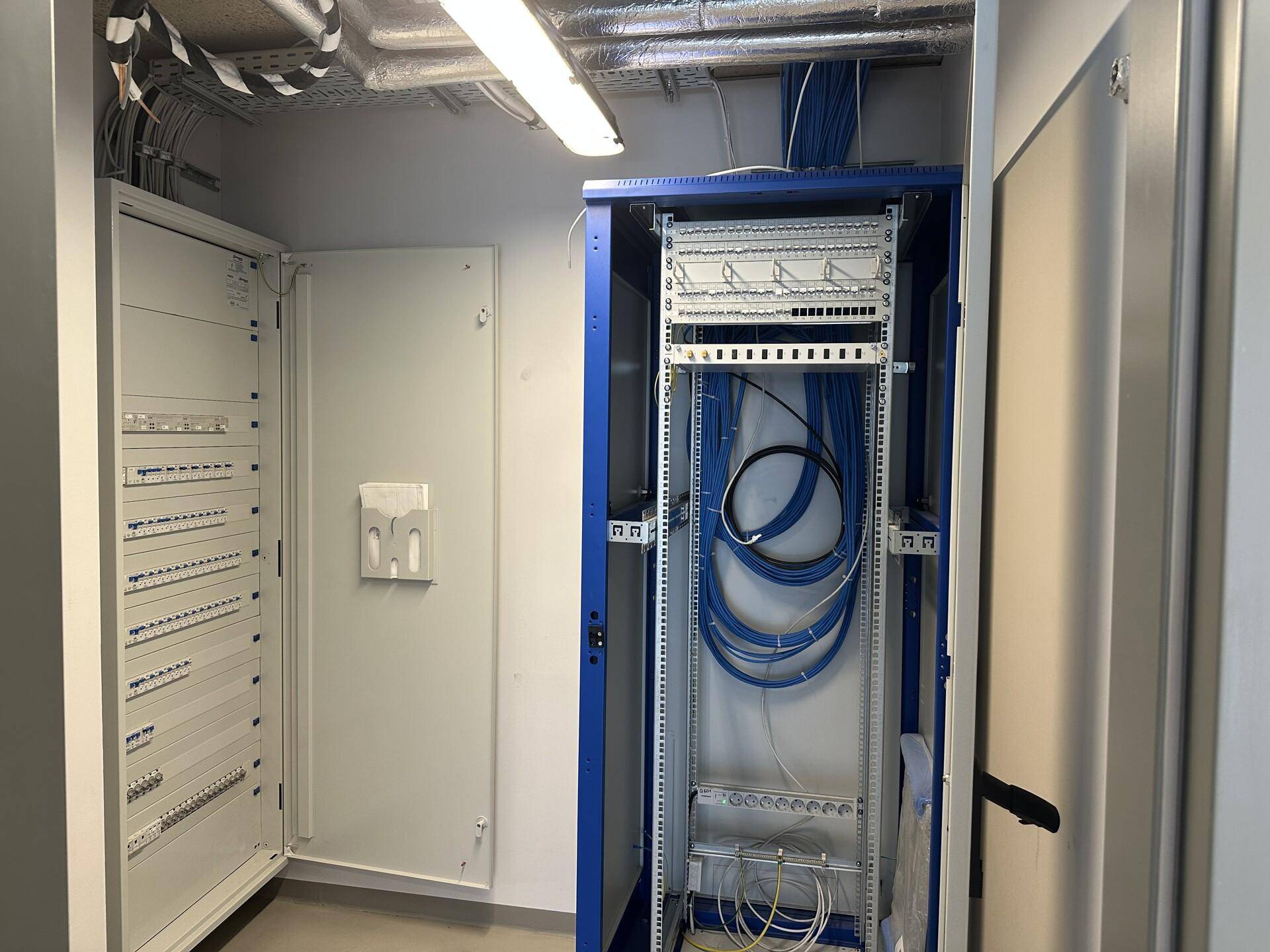 Technikraum mit sauber verlegten Kabeln, Serverschränken und elektrischen Verteilern.