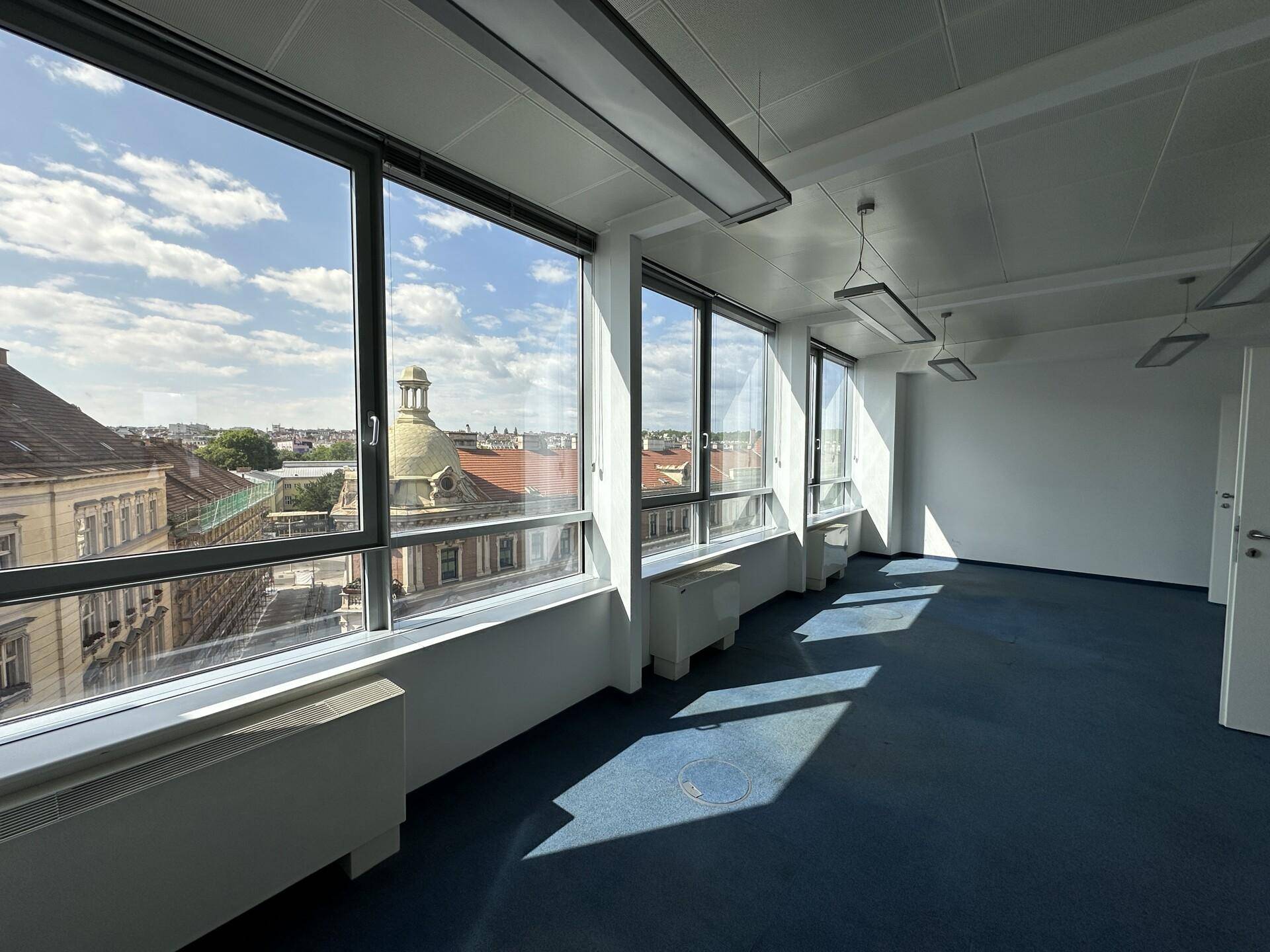 Großes Büro mit Panoramafenstern, die einen weiten Blick über die Stadt und eine Kuppel bieten.