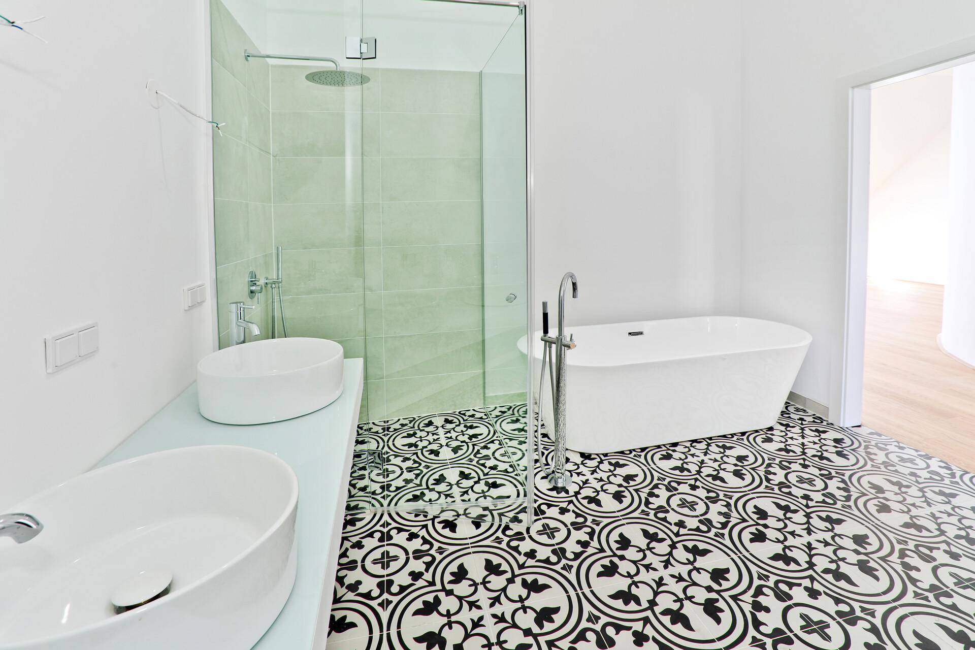 Elegantes Badezimmer mit freistehender Badewanne, Doppelwaschbecken und großer Glasdusche.