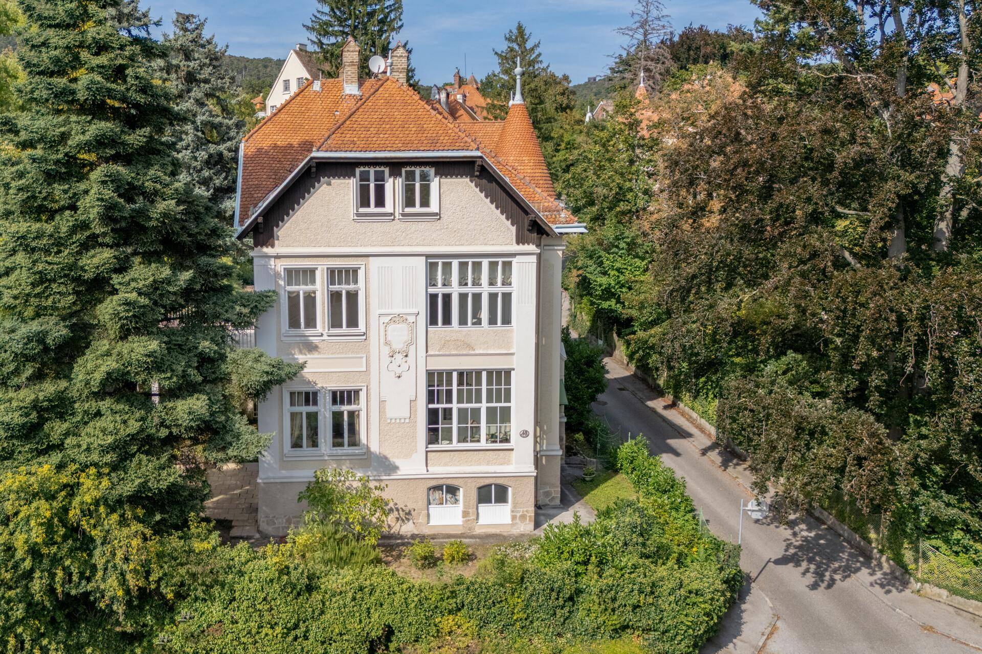 Luftaufnahme einer charmanten Villa mit Terrakotta-Dachziegeln und umgebender Natur.