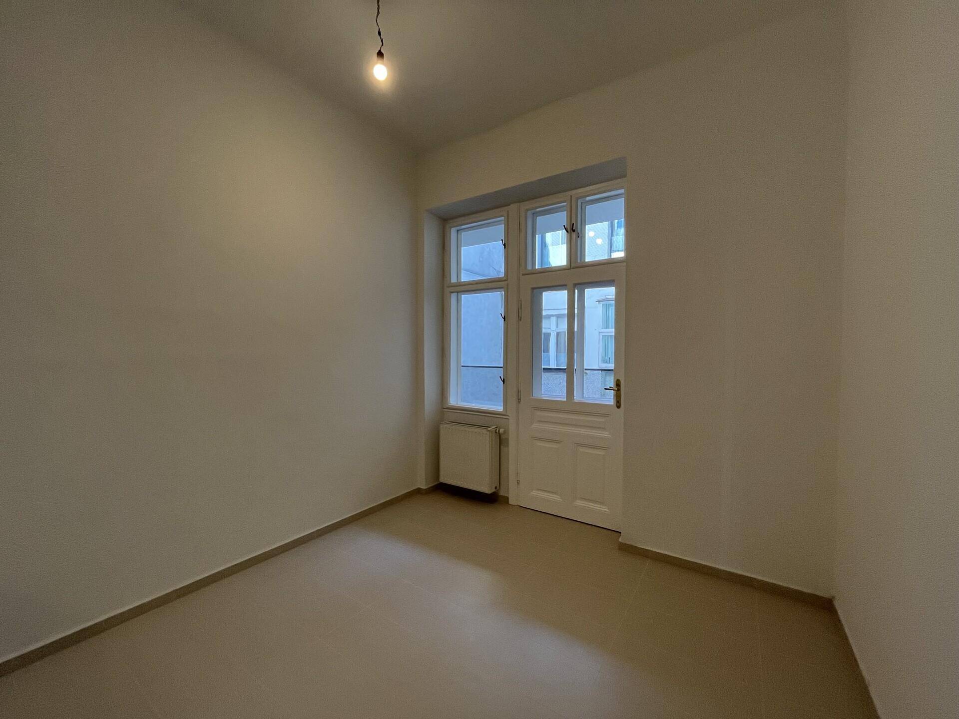 Helles Zimmer mit neutralen Wänden und Fenster, das viel Tageslicht bietet.