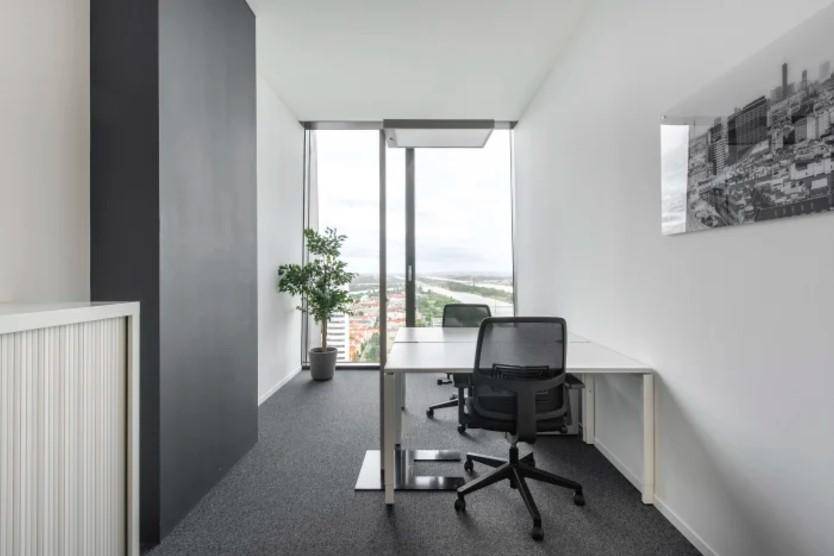Kleines Büro mit Schreibtisch und Bürostuhl, bietet einen weiten Blick auf die Stadt und den Fluss.