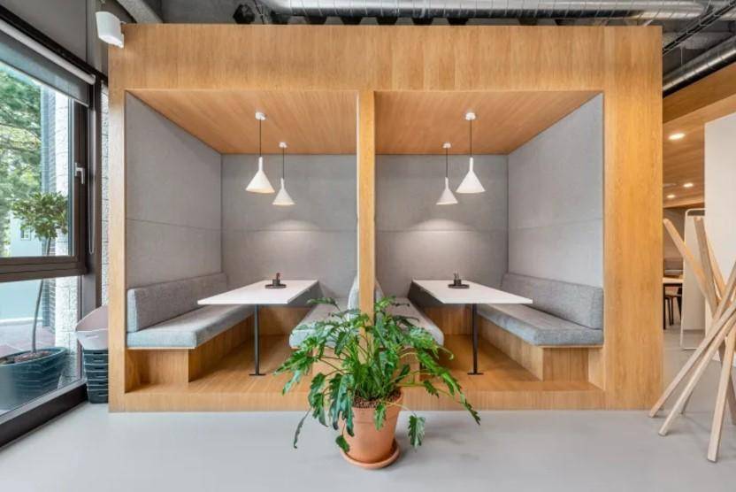 Gemütliche Sitznischen mit Holztäfelung und Pendelleuchten, ideal für private Gespräche oder Arbeit.
