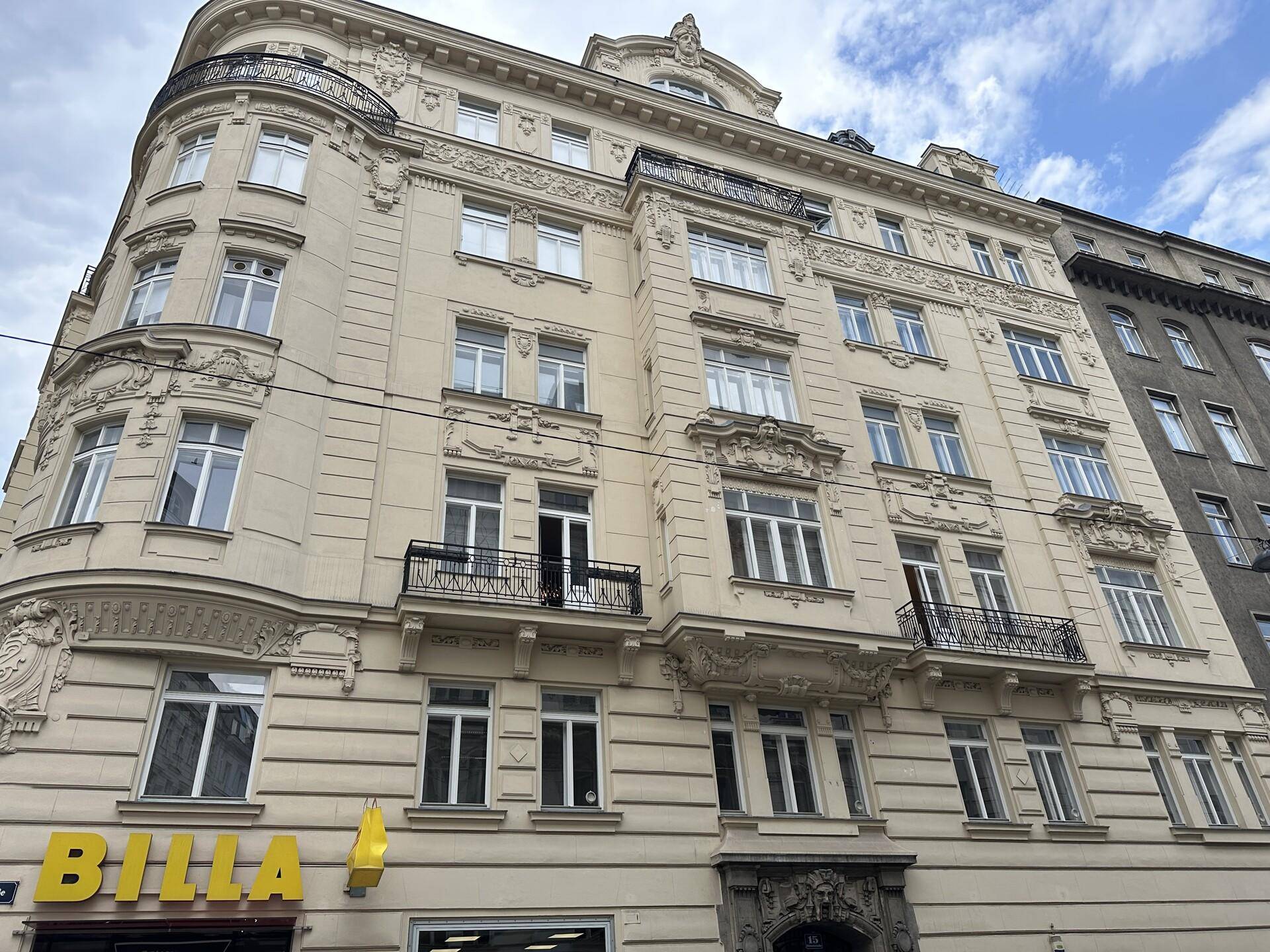 Prachtvolle Fassade eines Altbaus mit reich verzierten Details und Balkonen in der Stadt.