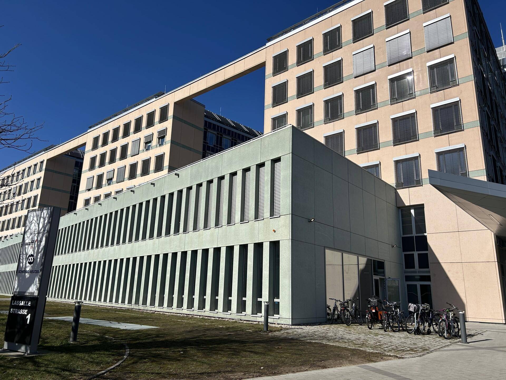 Weitläufiges Bürokomplex mit moderner Architektur, großen Fenstern und Grünflächen im Außenbereich.