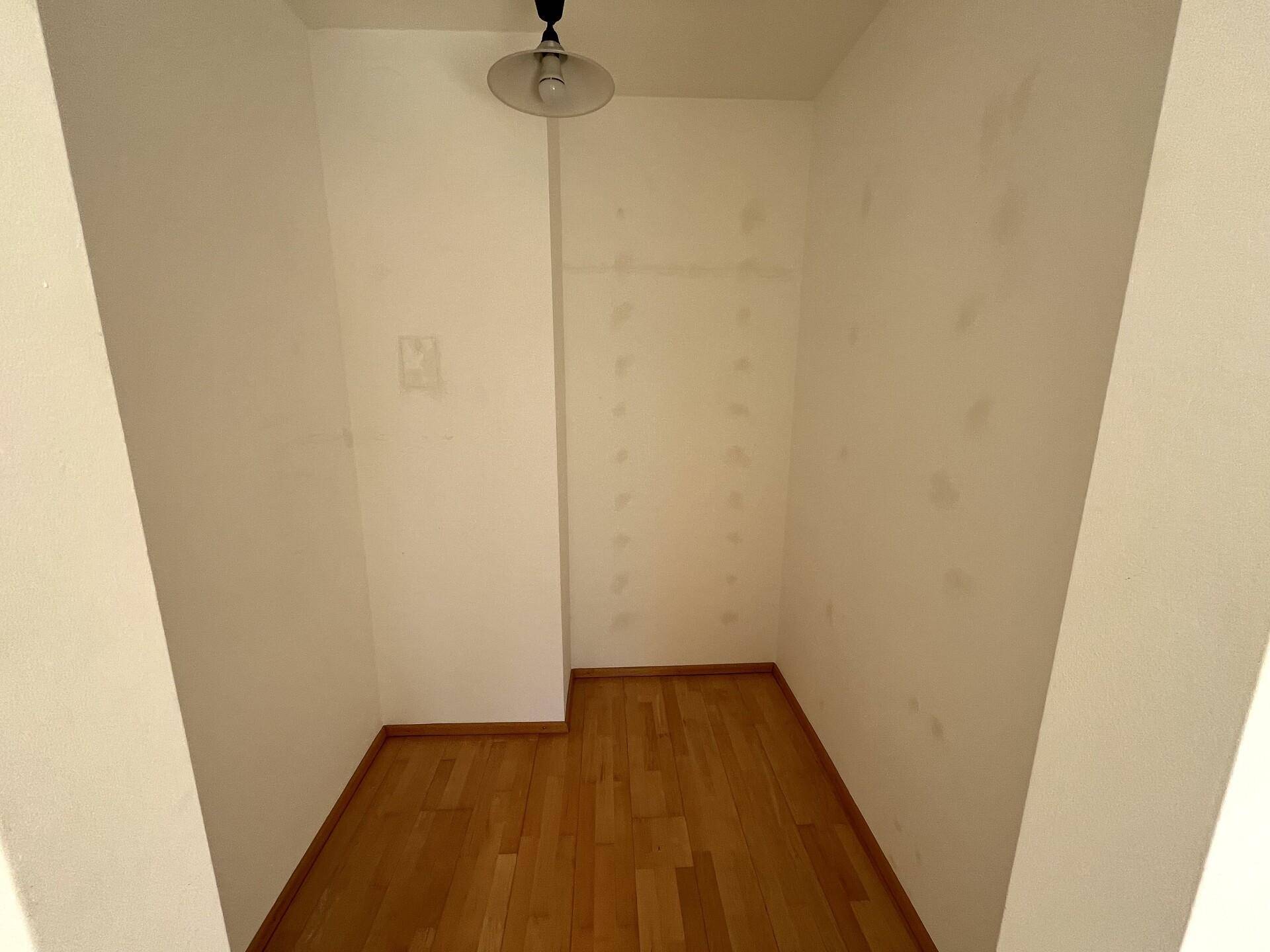Kleiner, leerer Raum mit Parkettboden, ideal als Abstellraum oder begehbarer Kleiderschrank.