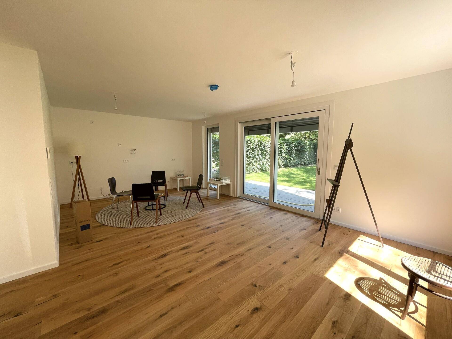 Geräumiges, helles Wohnzimmer mit Eichenparkett und großen Schiebetüren zum Garten.