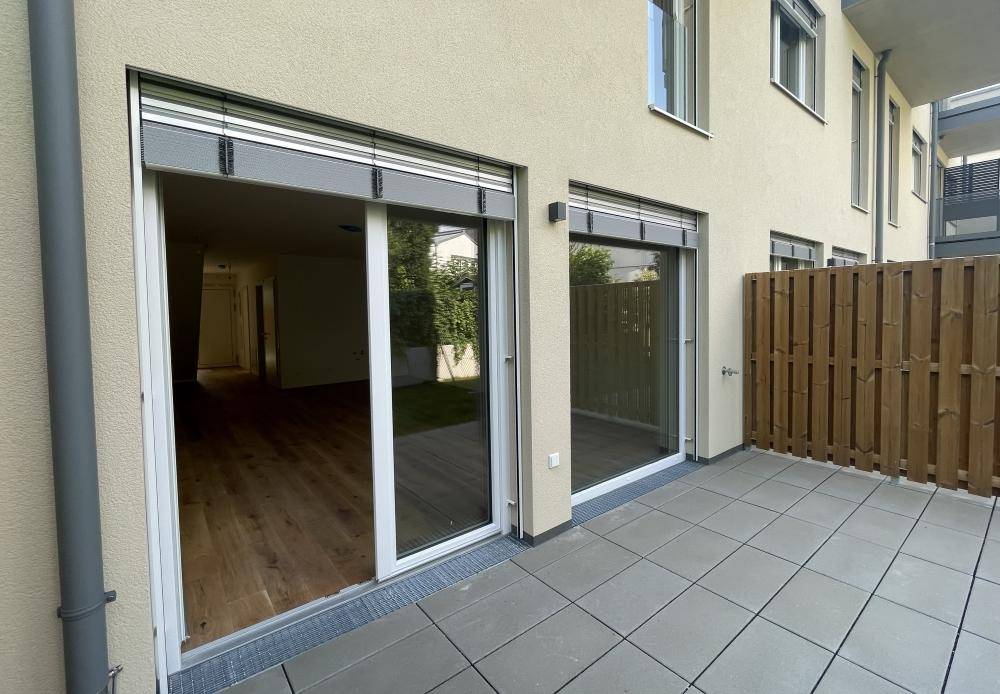 Gepflasterte Terrasse mit Zugang zu den Innenräumen durch große Schiebetüren.