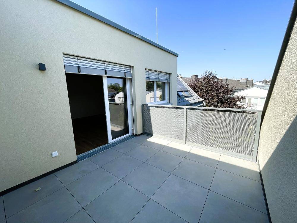 Geräumiger Balkon mit modernem Metallgeländer und Fliesenboden, perfekt für sonnige Tage.