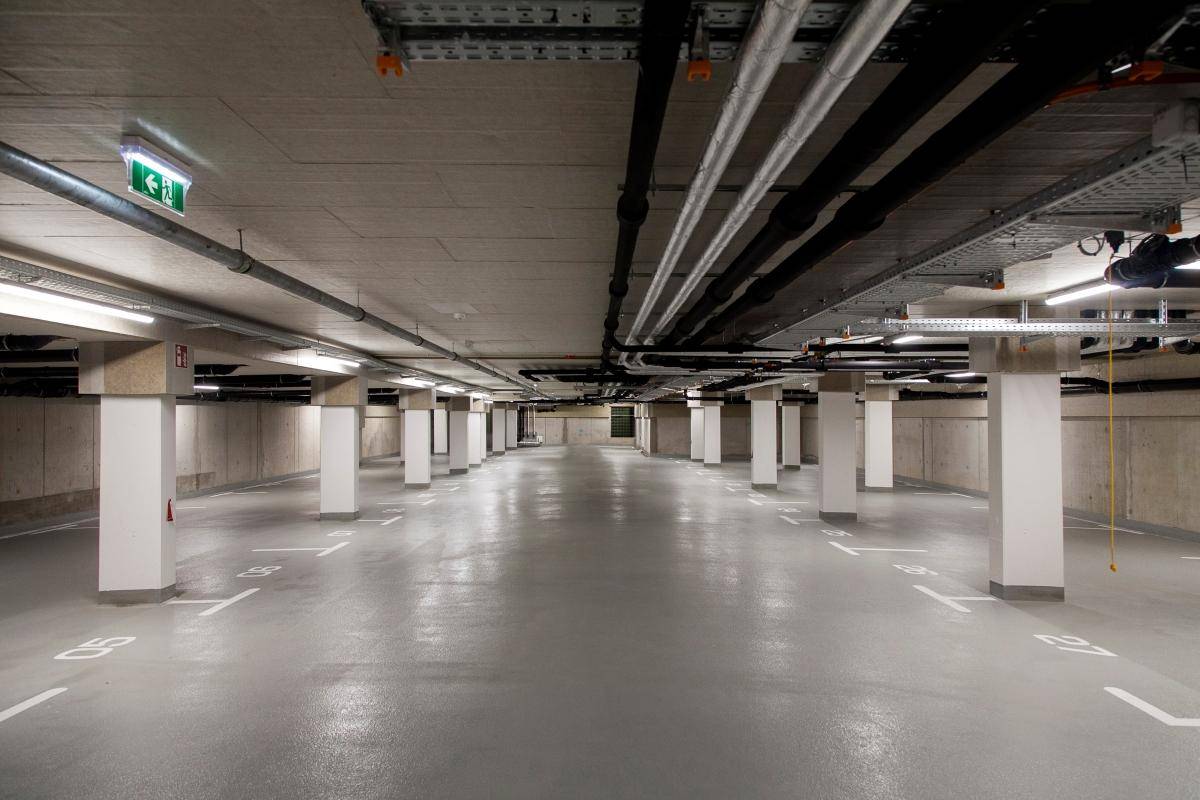 Geräumige Tiefgarage mit vielen Stellplätzen, Säulen und guter Beleuchtung.