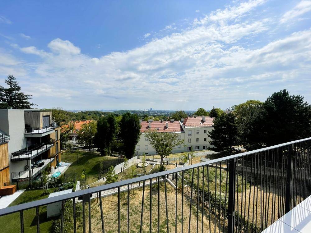 Panoramablick von der Terrasse auf grüne Umgebung und die Dächer der Stadt.