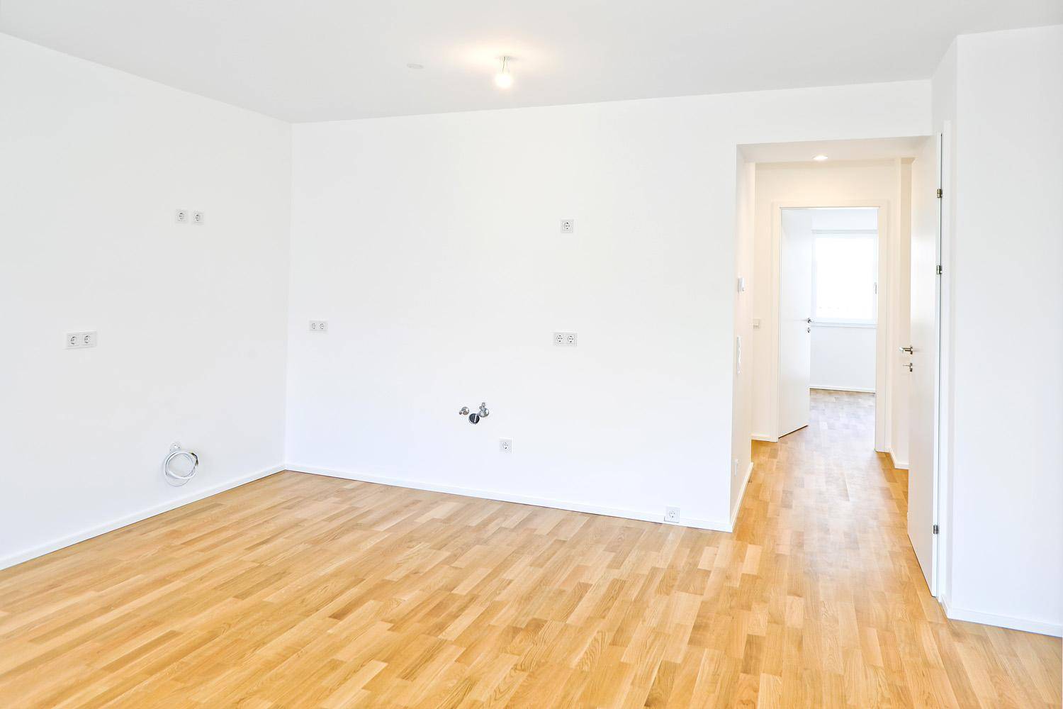 Geräumiges, helles Zimmer mit Parkettboden und Zugang zum Flur.