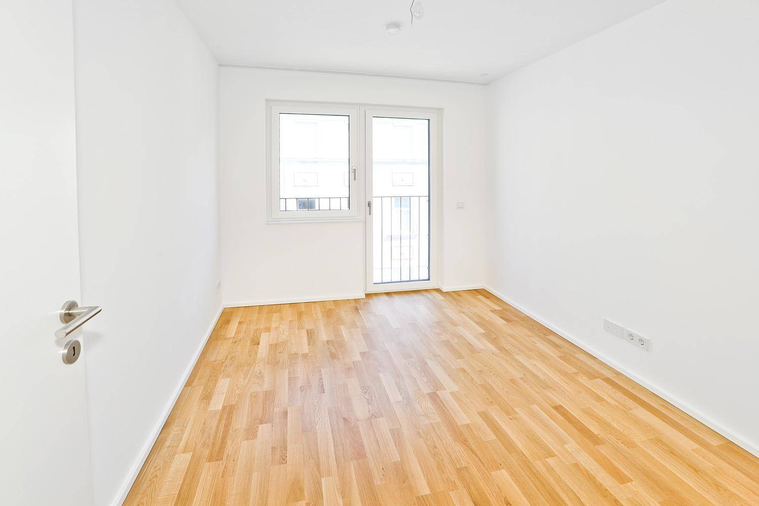 Geräumiges Schlafzimmer mit Parkettboden und viel Tageslicht.
