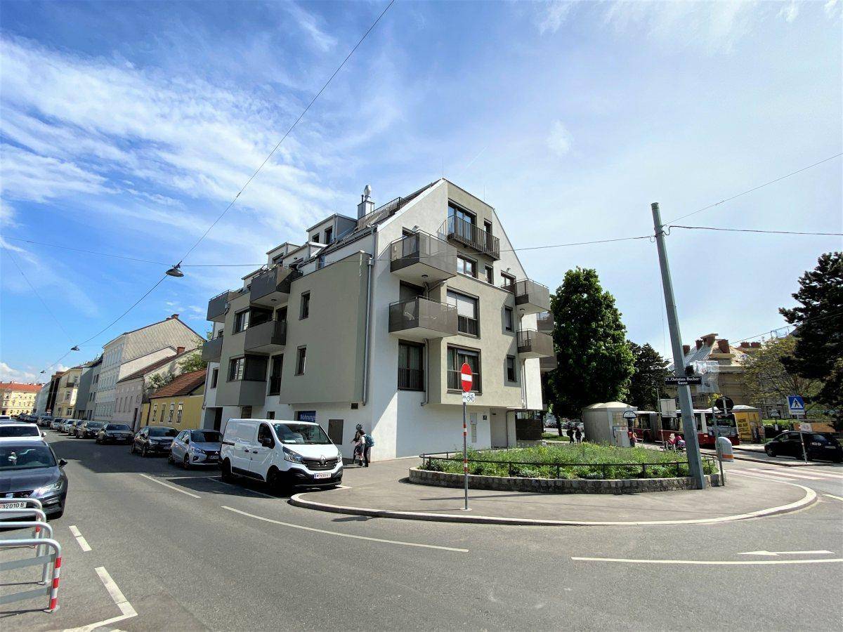Modernes Wohngebäude mit mehreren Balkonen und zeitgenössischer Architektur an einer Straßenecke.
