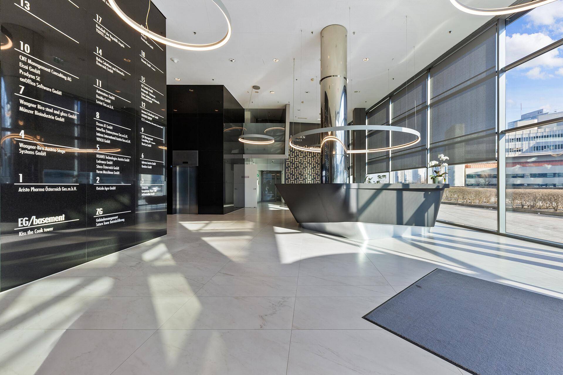 Elegante Lobby mit modernem Empfangstresen, glänzenden Fliesen und dekorativer Beleuchtung.