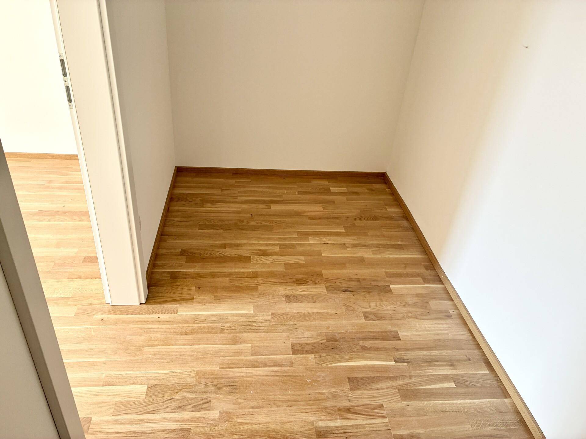 Kleiner, leerer Raum mit Holzboden, möglicherweise als Abstellraum oder begehbarer Schrank nutzbar.