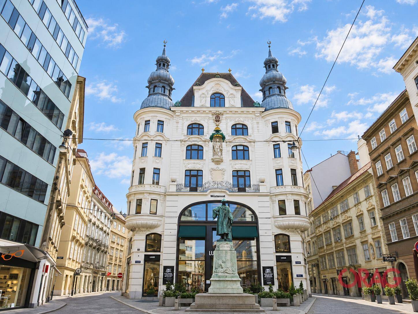 Prachtvolles historisches Gebäude mit aufwendiger Fassade und einer Statue auf einem belebten Stadtplatz.