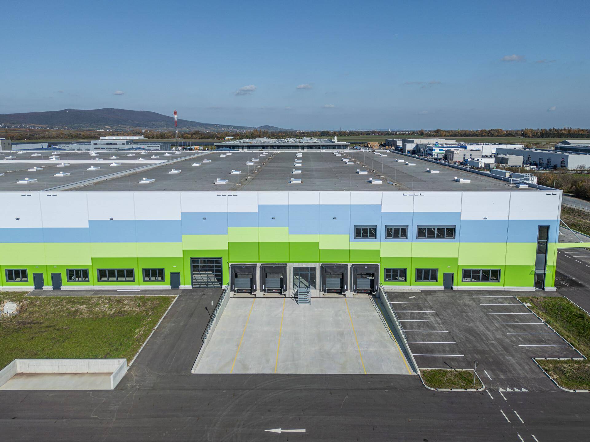 Nahaufnahme der Laderampen einer modernen Industriehalle mit farbiger Fassade und großzügigen Zufahrtsbereichen.