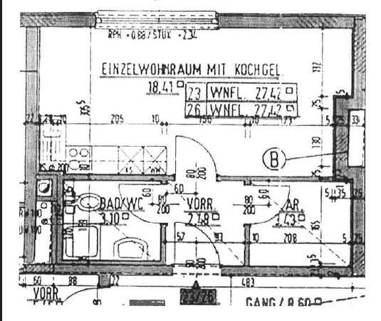 Grundriss einer Wohnung mit kombiniertem Wohn-Kochbereich, Bad/WC und separaten Abstellräumen.