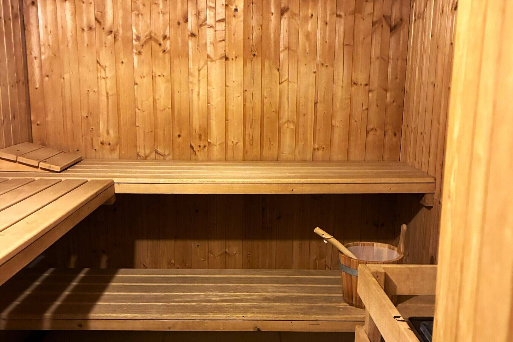 Traditionelle Holzsauna mit mehreren Bänken und typischem Saunaofen.