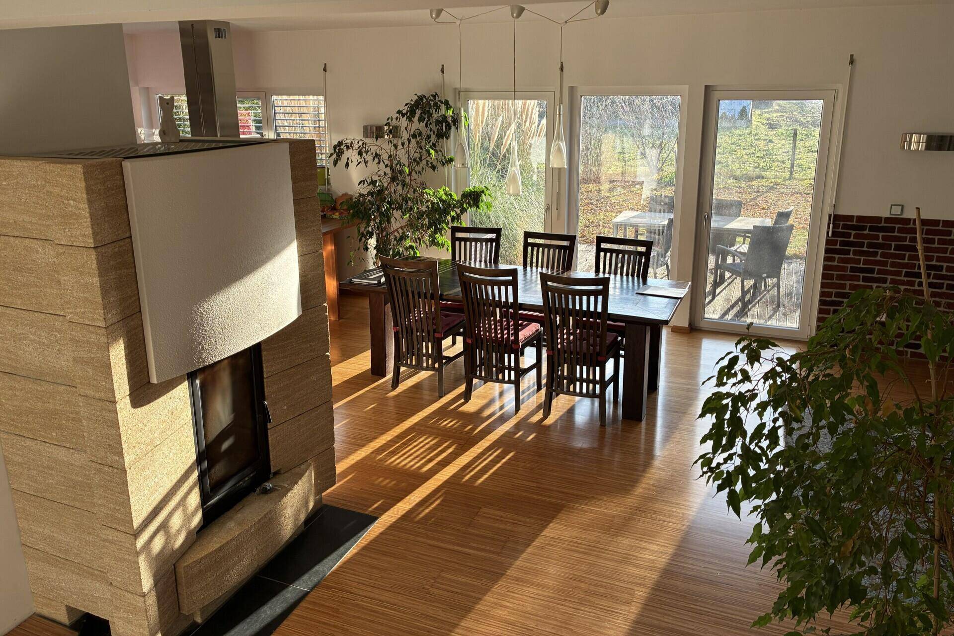 Lichtdurchfluteter Essbereich mit Holztisch, Stühlen und Zugang zur Terrasse.