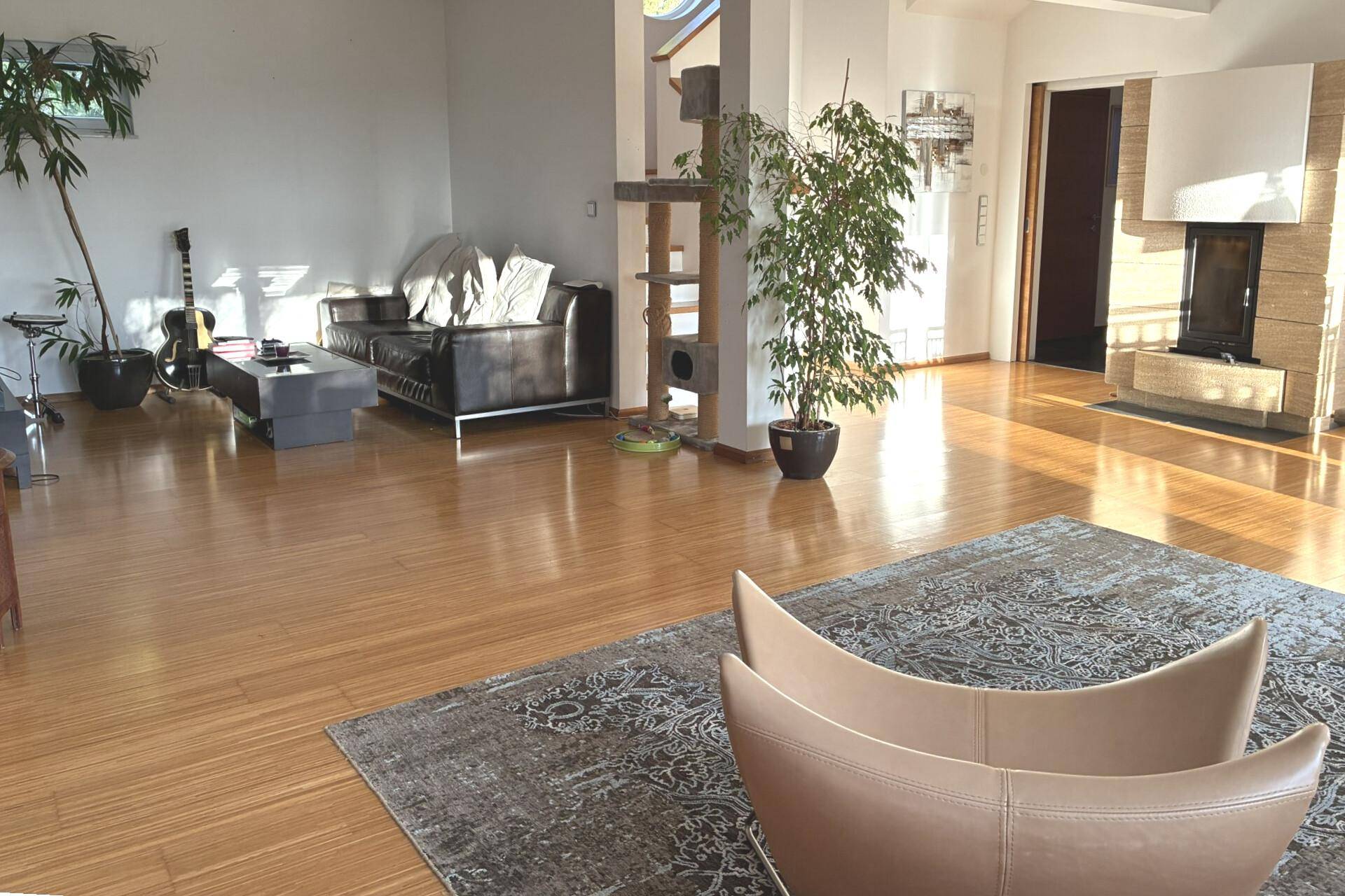 Helles und geräumiges Wohnzimmer mit glänzendem Parkettboden und modernem Kamin.