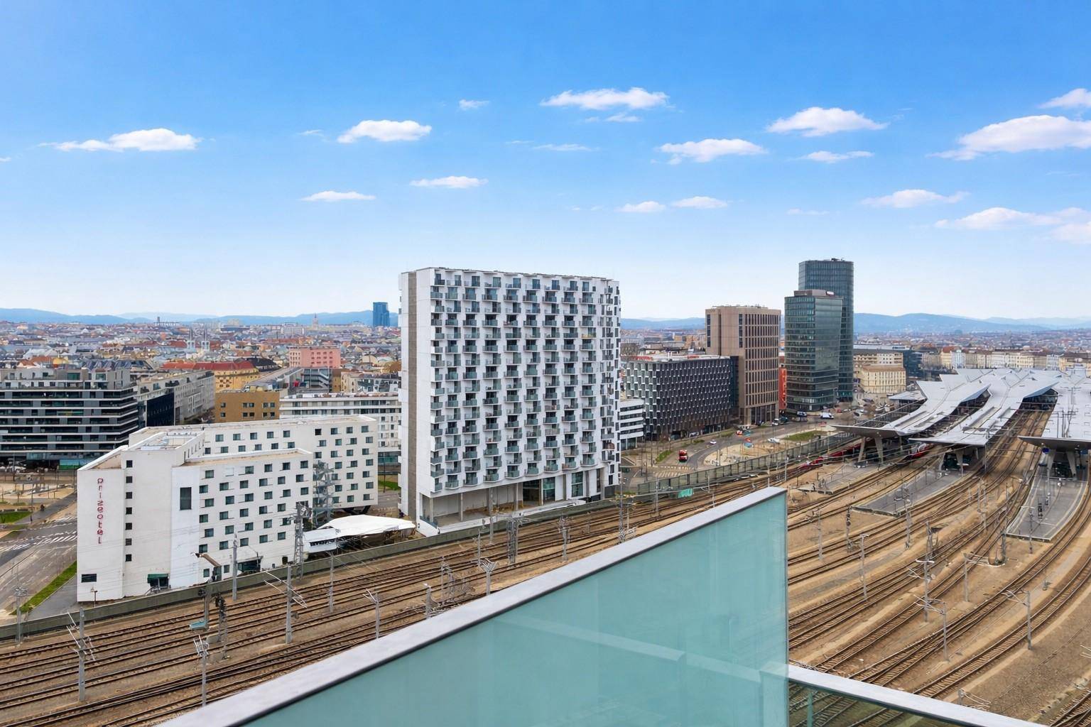 Panoramablick über die Stadt mit modernen Hochhäusern und dem Wiener Hauptbahnhof.