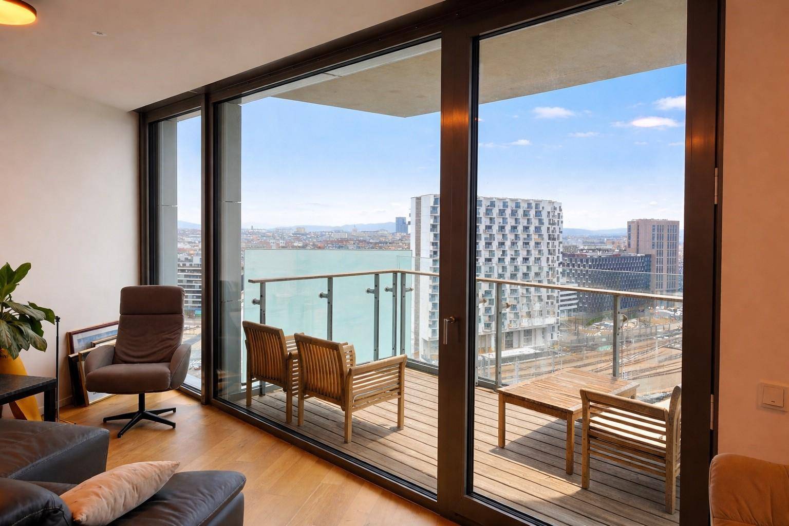 Helles Wohnzimmer mit großen Schiebetüren zum Balkon und weitem Stadtblick.