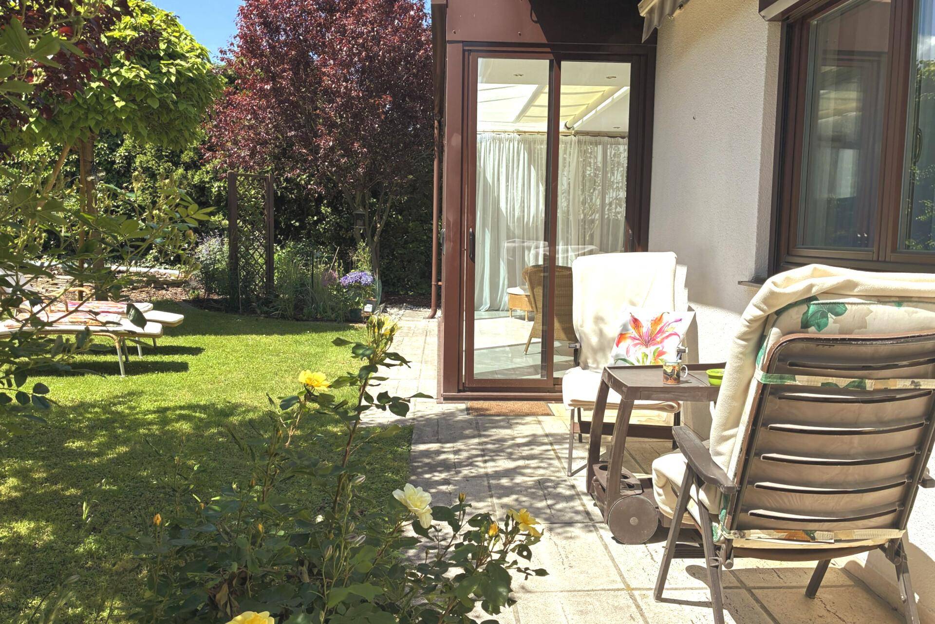 Gemütliche Terrasse mit Sitzgelegenheiten und direktem Zugang zum blühenden Garten.