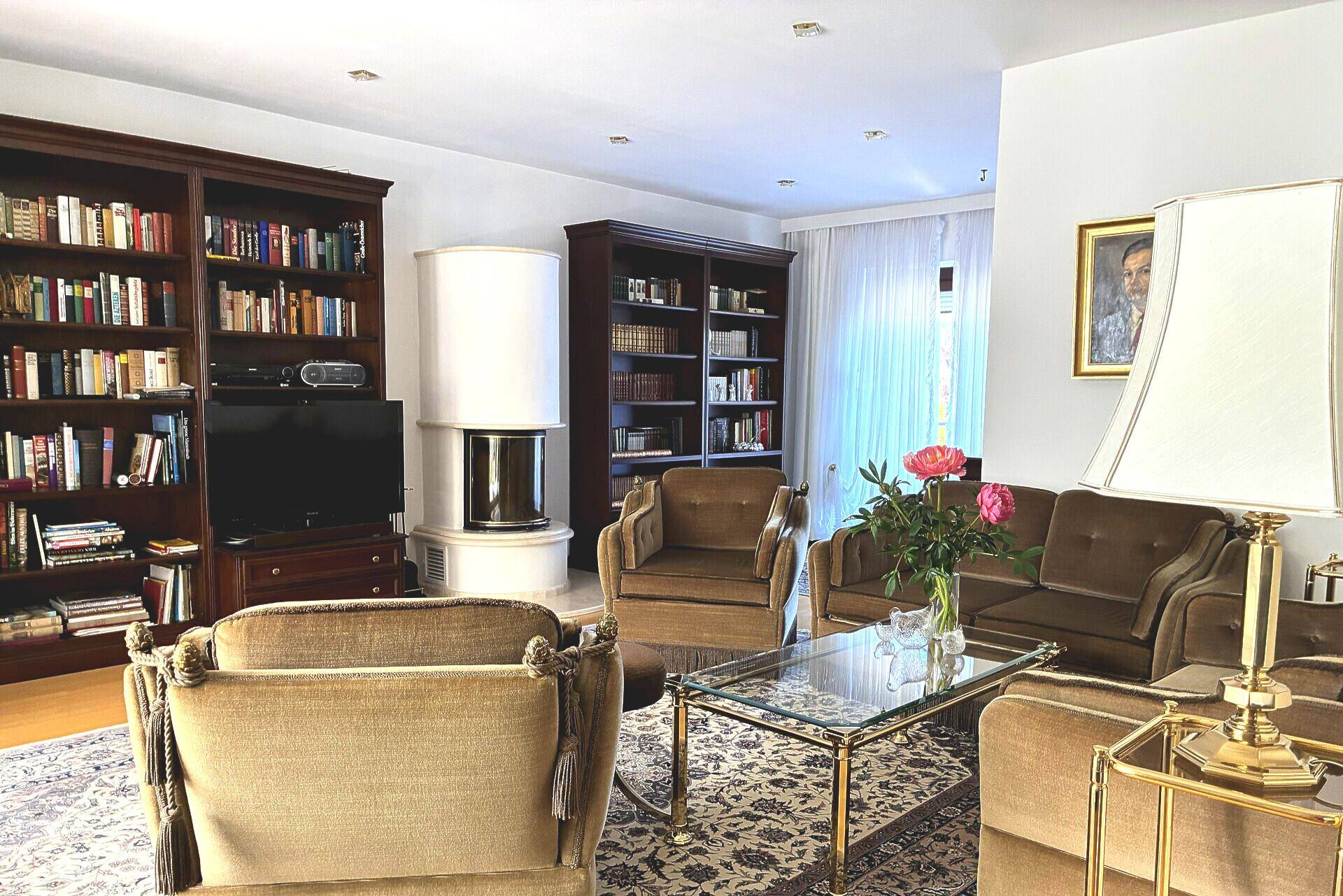 Geräumiges Wohnzimmer mit Bücherregalen, Kamin und bequemen Sofas in klassischem Stil.