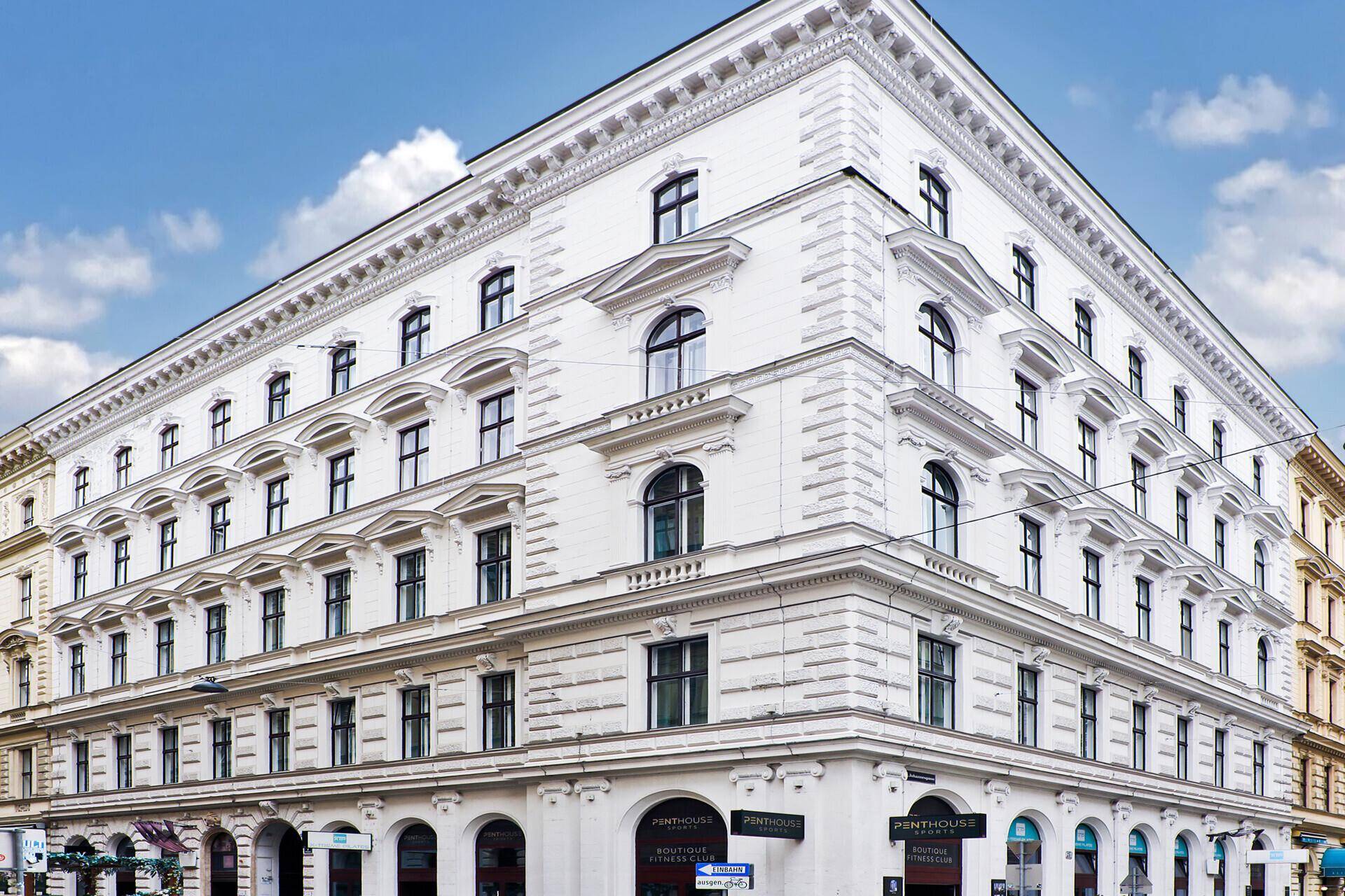 Historisches Gebäude mit klassischer Fassade und modernen Penthouses im Dachgeschoss.
