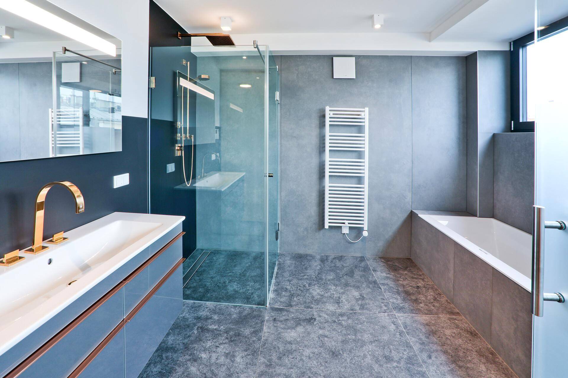 Elegantes Badezimmer mit Dusche, Badewanne, beheiztem Handtuchhalter und modernen Fliesen.