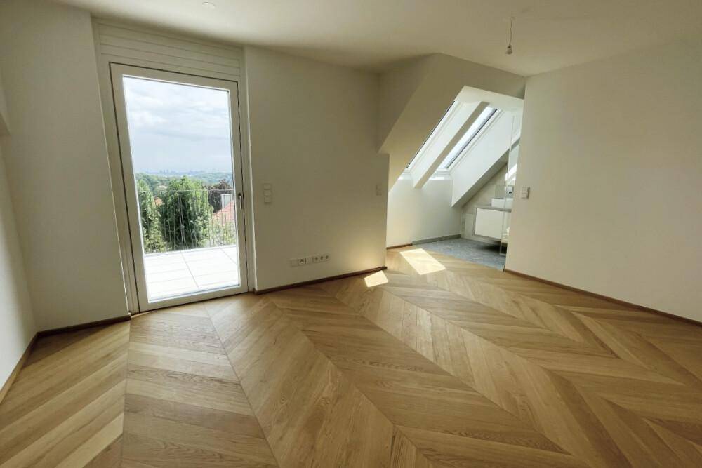 Geräumiges Zimmer mit Fischgrätparkett und direktem Zugang zur sonnigen Terrasse.