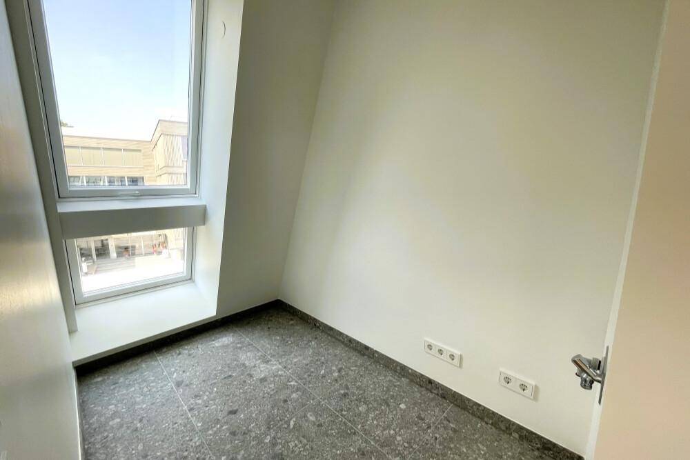 Kleiner Raum mit Fliesenboden und schrägem Fenster, ideal als Abstellraum.