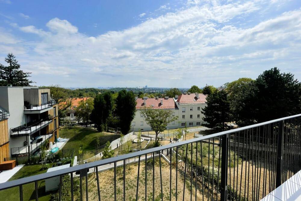 Panoramablick von der Terrasse auf die umliegenden Gebäude und eine gepflegte Grünanlage.
