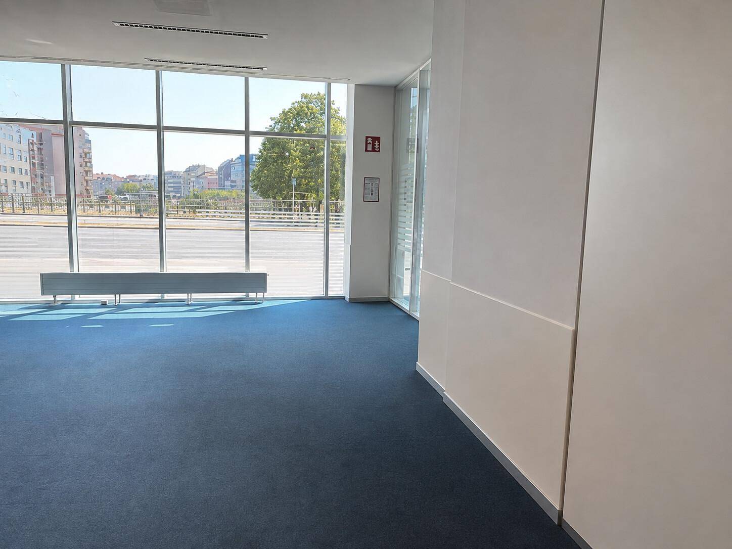 Geräumiger Bürobereich mit weitem Blick nach draußen und durchgehenden Fensterfronten.