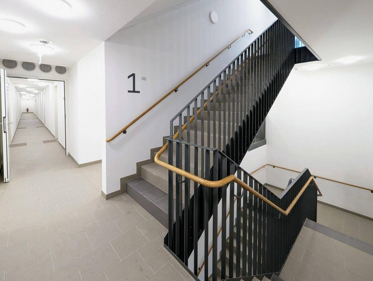 Modernes Treppenhaus und Flur in einem Mehrfamilienhaus mit klarem Design.