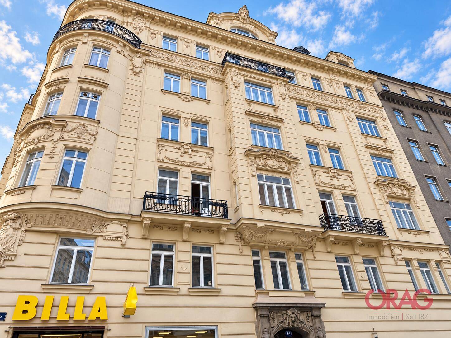 Prachtvolles Altbaugebäude mit vielen Fenstern, Balkonen und einer markanten Fassade.