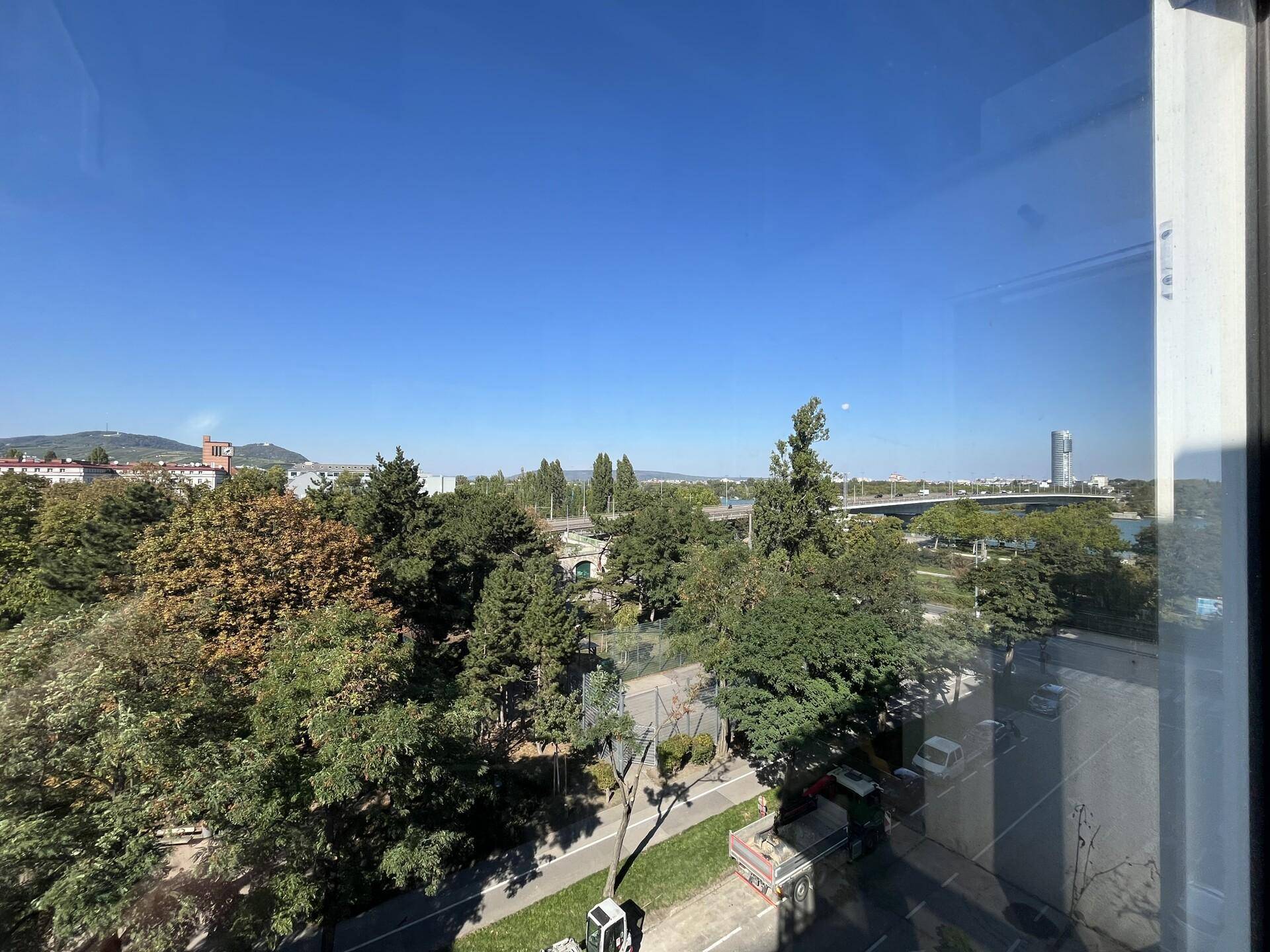 Panoramablick aus dem Fenster auf die grüne Umgebung, die Donau und die Stadt.