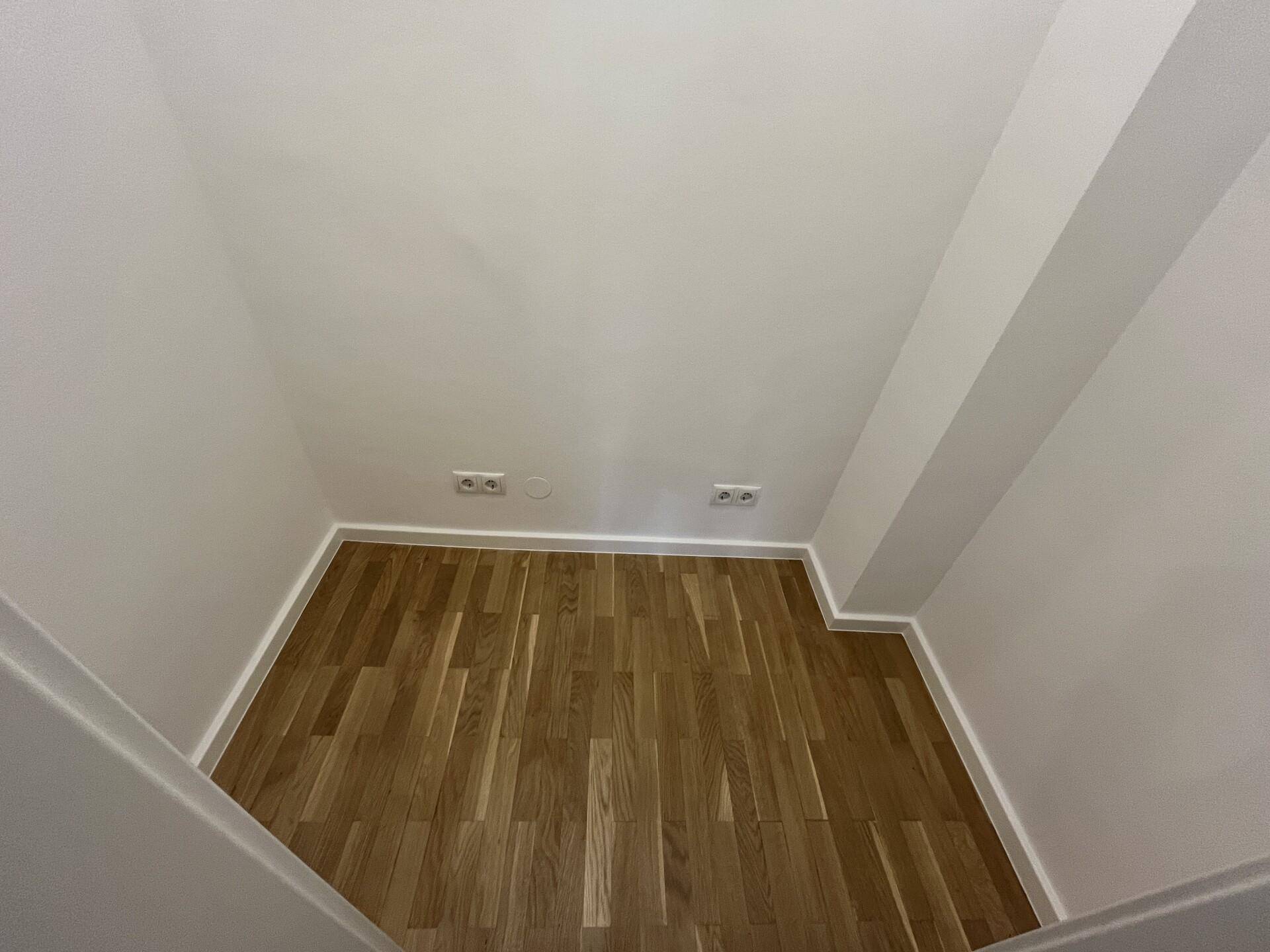 Kleiner Abstellraum mit Parkettboden und weißen Wänden, ideal für zusätzlichen Stauraum.