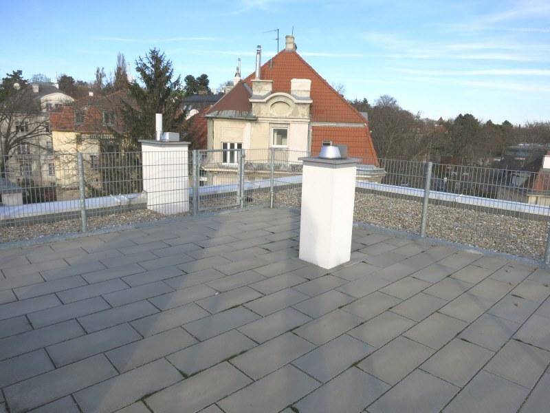 Weitläufige Dachterrasse mit Fliesenboden und Panoramablick über die Umgebung.