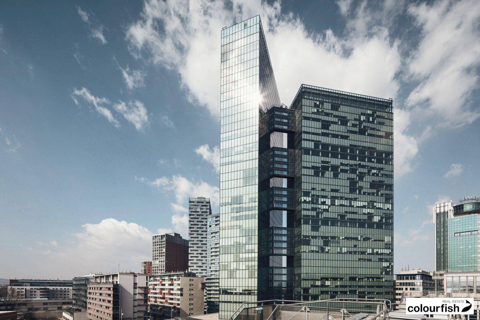 Beeindruckende moderne Hochhäuser mit Glasfassaden unter einem blauen Himmel mit Wolken.