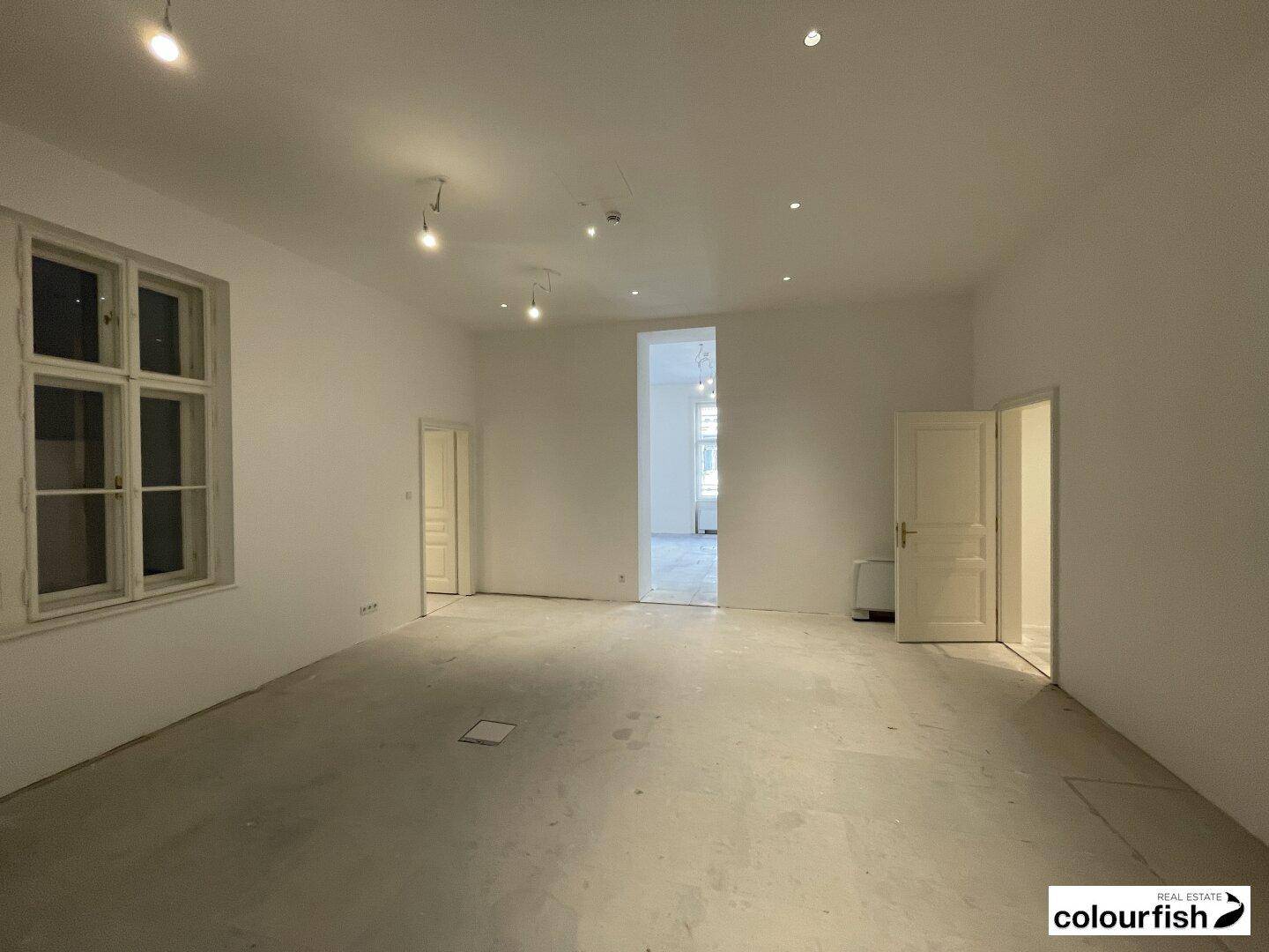 Geräumiger, unmöblierter Büroraum mit hohen Decken und Blick auf den Innenhof, bereit für den Ausbau.