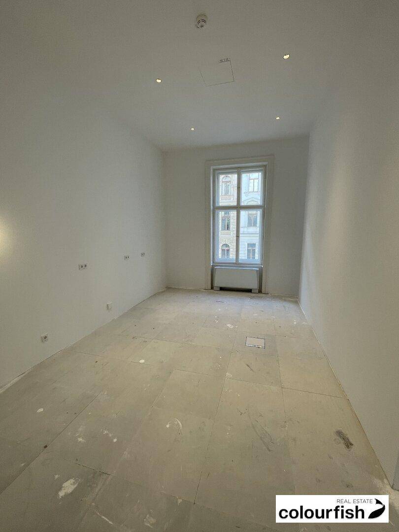 Kleiner, heller Büroraum mit einem Fenster und schlichten weißen Wänden, ideal für Einzelbüros.
