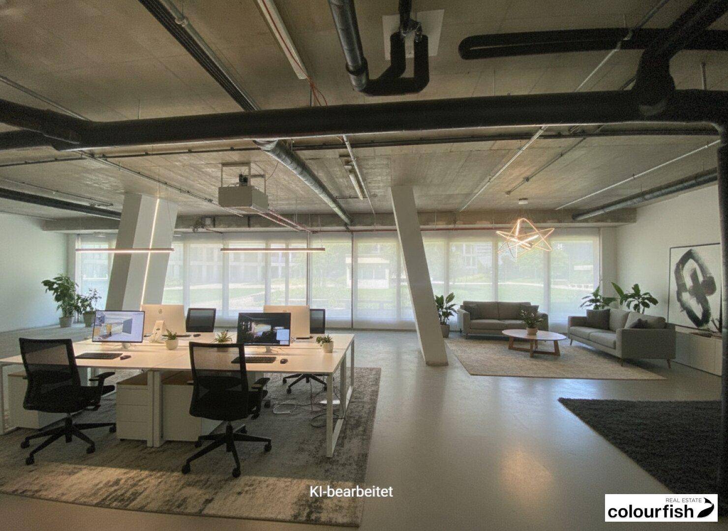 Modernes Großraumbüro mit hohen Decken, freiliegenden Rohren und viel Tageslicht durch große Fenster.
