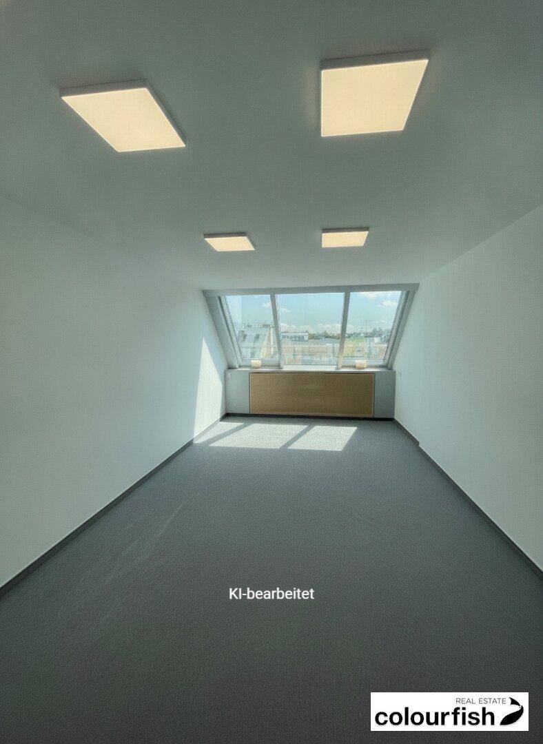 Helles, leeres Büro mit schrägen Fenstern und grauem Teppichboden, bereit zur Einrichtung.