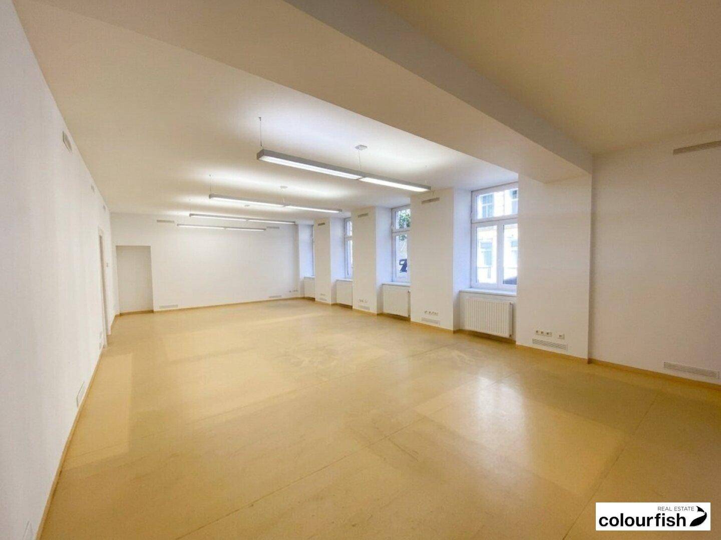 Weitläufiger Innenraum mit hohen Decken, großen Fenstern und funktionaler Beleuchtung, vielseitig nutzbar.