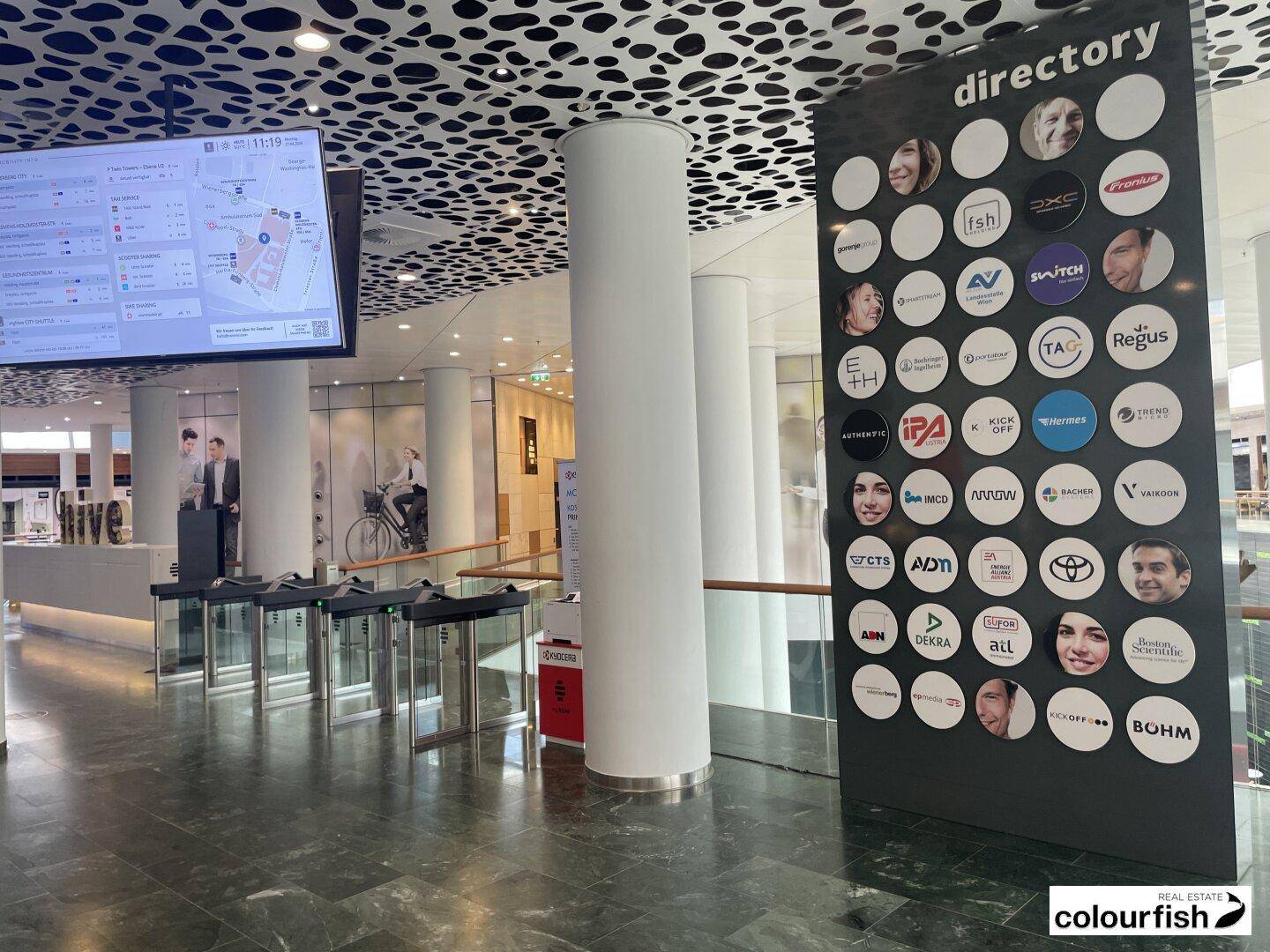 Helle und moderne Lobby mit einem großen Firmenverzeichnis und Zugangsbereich.